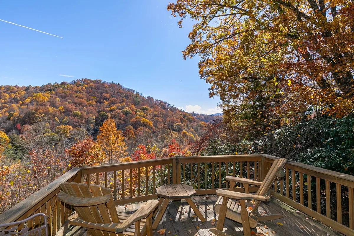 A wide wooden deck opens to stunning mountain views accented by autumn foliage. The deck offers plenty of space for relaxing, socializing, or savoring a morning coffee while soaking in the panorama.
